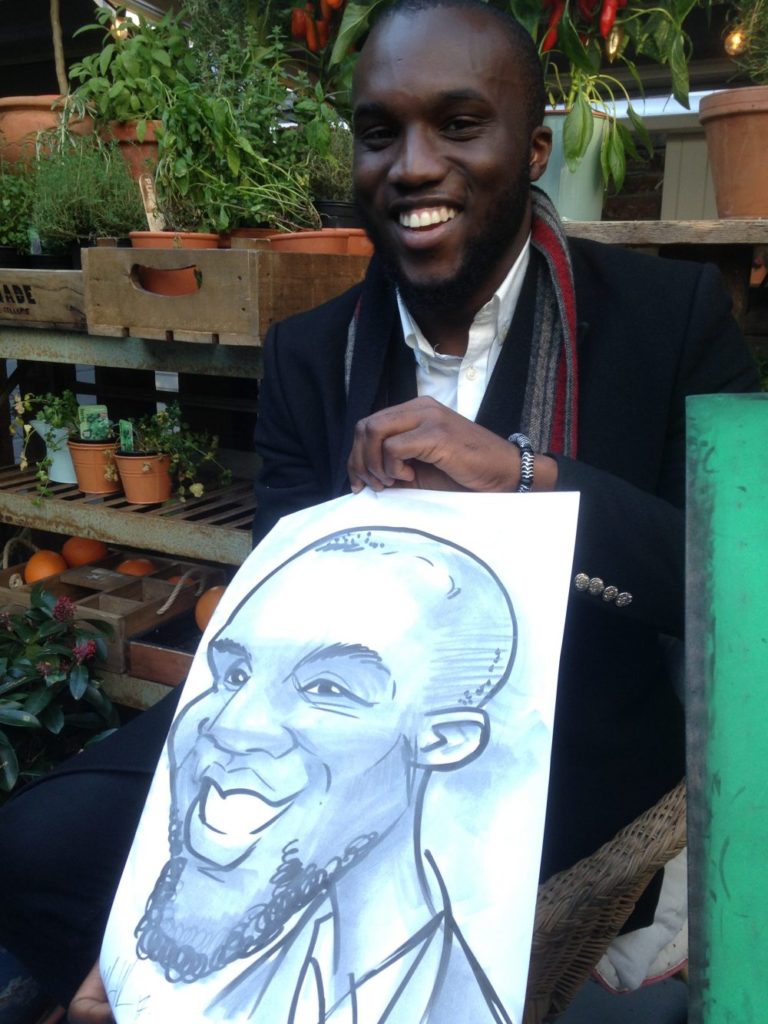 Man in black jacket laughing with caricature by Allan Cavanagh