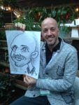 Man in grey top with live caricature by Allan Cavanagh