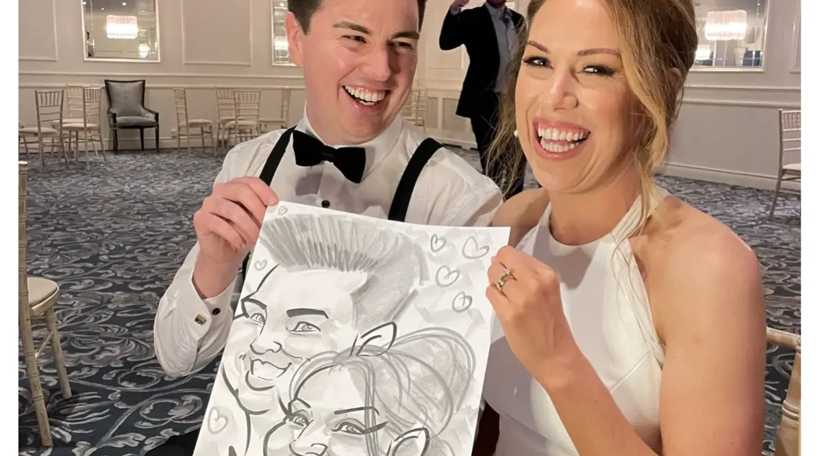 Galway Wedding Entertainment Hardiman Hotel Caricaturist Allan Cavanagh. Newlywed man and woman holding a black and white caricature of themselves and laughing