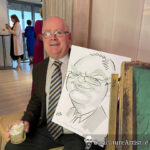 Seated man with caricature, laughing, wearing a suit