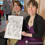 Young couple seated holding caricature and laughing