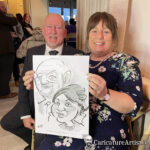 Laughing couple holding caricature by Allan Cavanagh