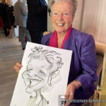 Seated woman laughing holding caricature of herself and laughing