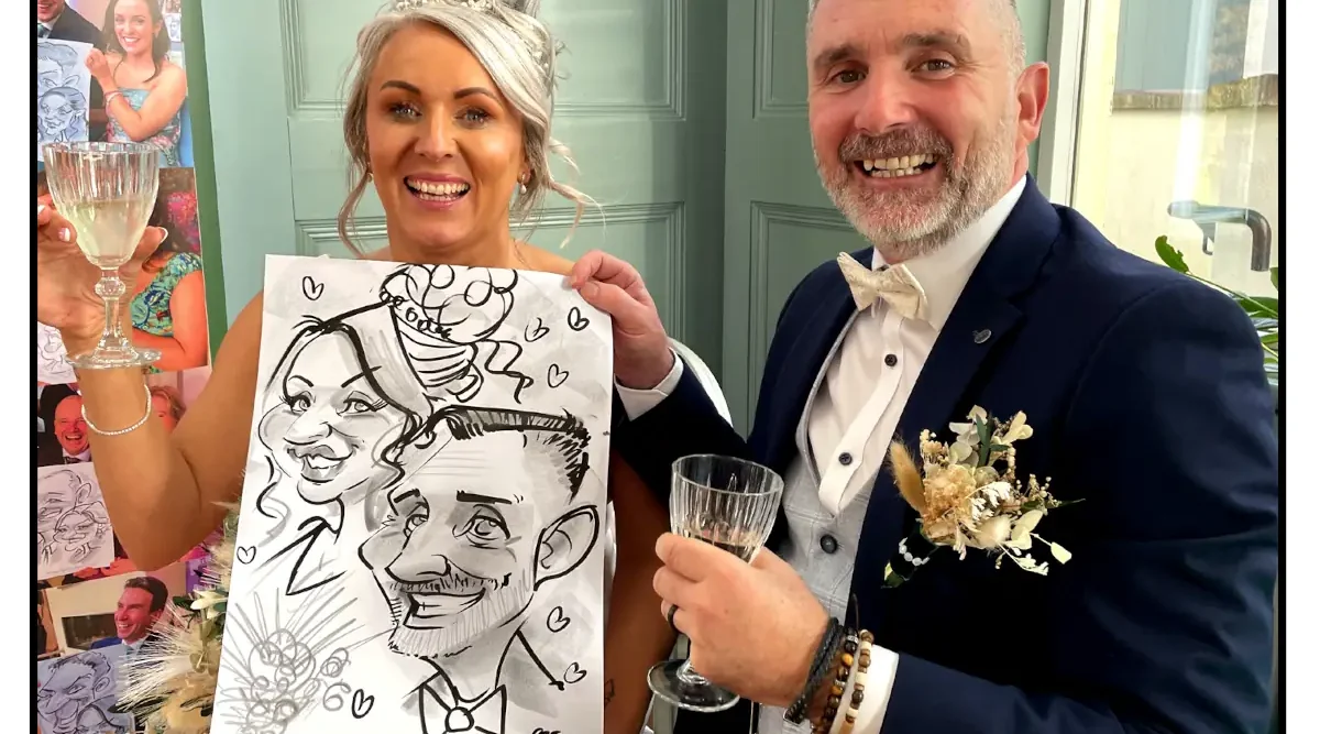 Newlywed couple holding their caricature by Allan Cavanagh. Blonde bride is on the left, a bearded groom on the right, both laughing and holding champagne. Newbay House Wexford Wedding Photos