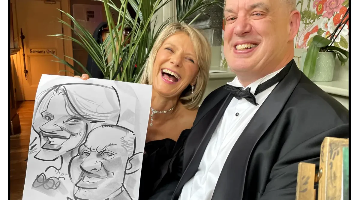 Photo of a laughing woman and man at a wedding holding a caricature of themselves by Allan Cavanagh. Ballyseede Castle Hotel Tralee Kerry Wedding Entertainment Ideas